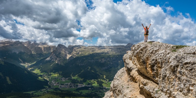 woman at top of mountain celebrating success
